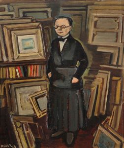 A painting of Berthe Weill. Weill is depicted wearing a black dress and glasses, and she’s standing in front of stacks of paintings and picture frames.