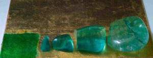 Verdigris glaze; raw, unpolished emerald; three quench-cracked crystals dyed green with verdigris dissolved in hot oleoresin. 